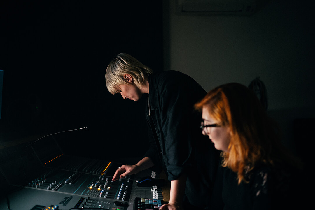 A pair of students working on a production desk.