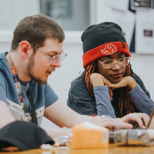 two students looking at their laptop