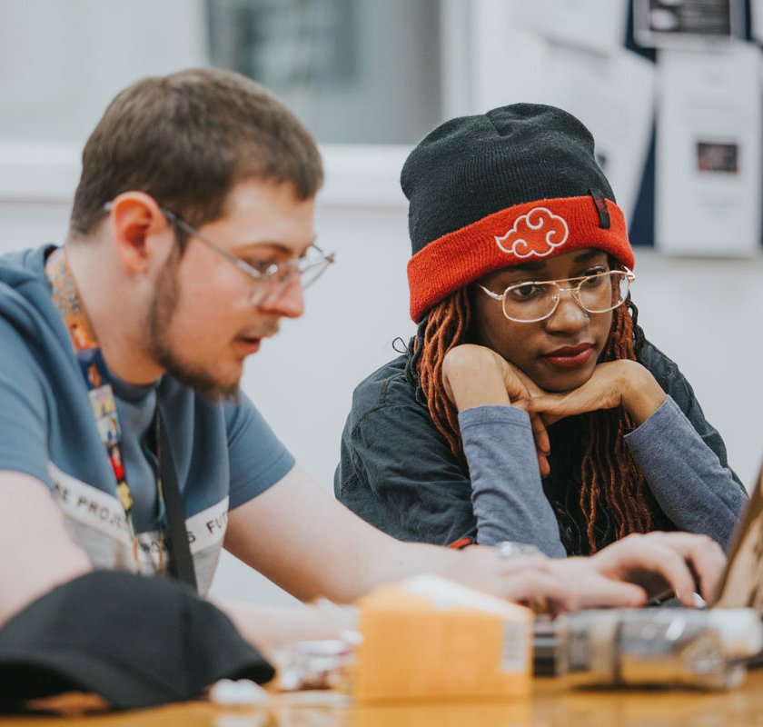 two students looking at their laptop