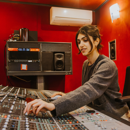 A close up of a student working on a recording desk.