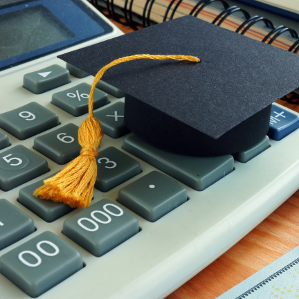 A picture of a graduate hat on top of a calculator.