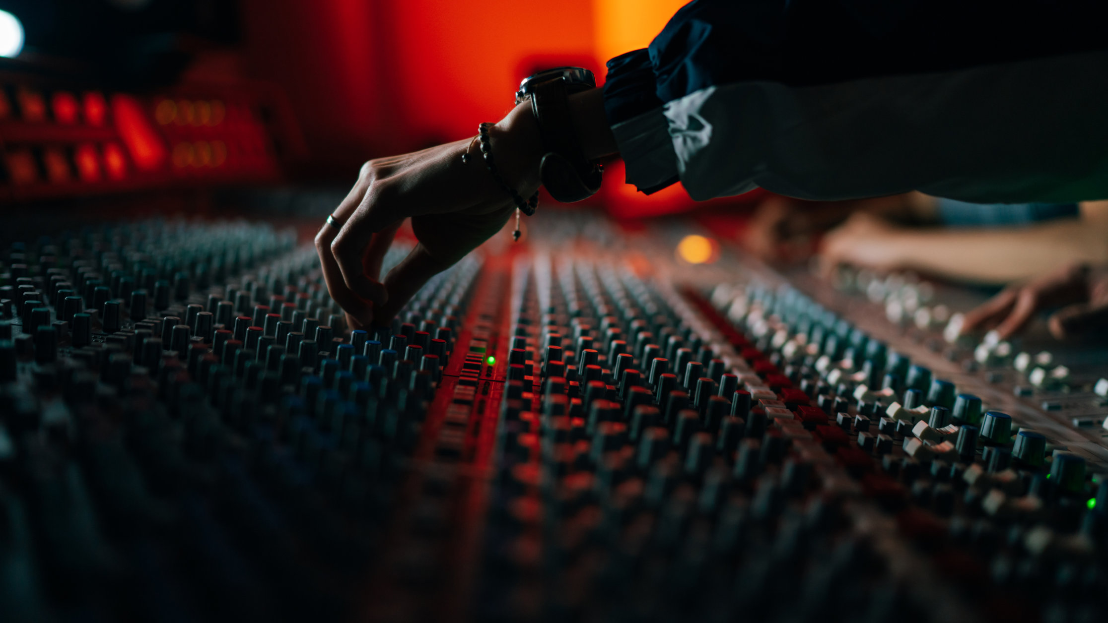 A close up of a pair of hands working on a production desk.