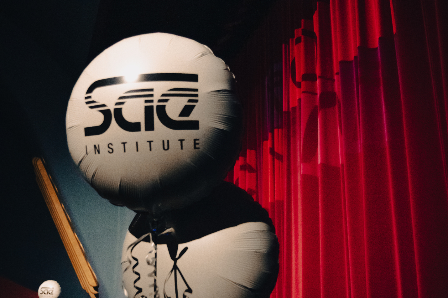 two white balloons with the SAE logo